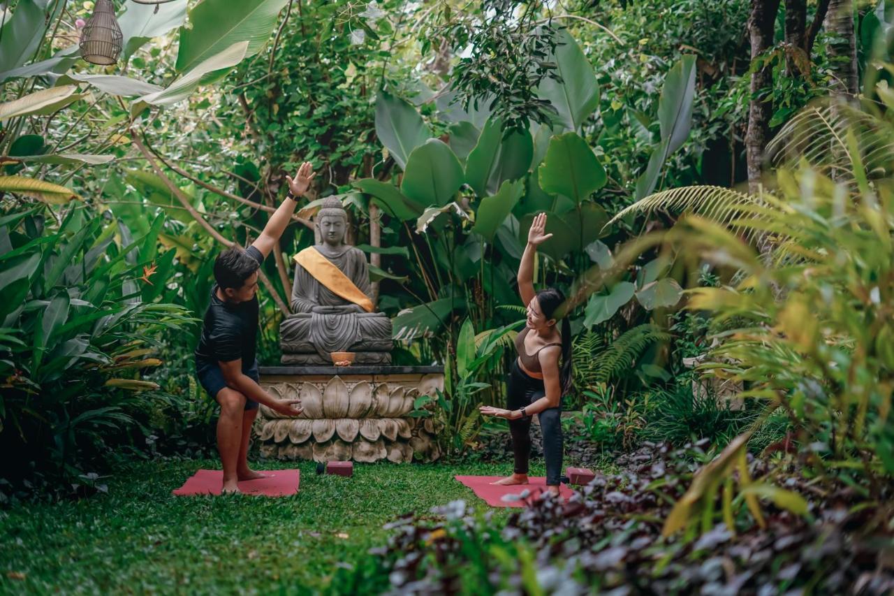 Ubud Nyuh Bali Resort & Spa Exteriér fotografie A yoga teacher training a student in Bali, Indonesia